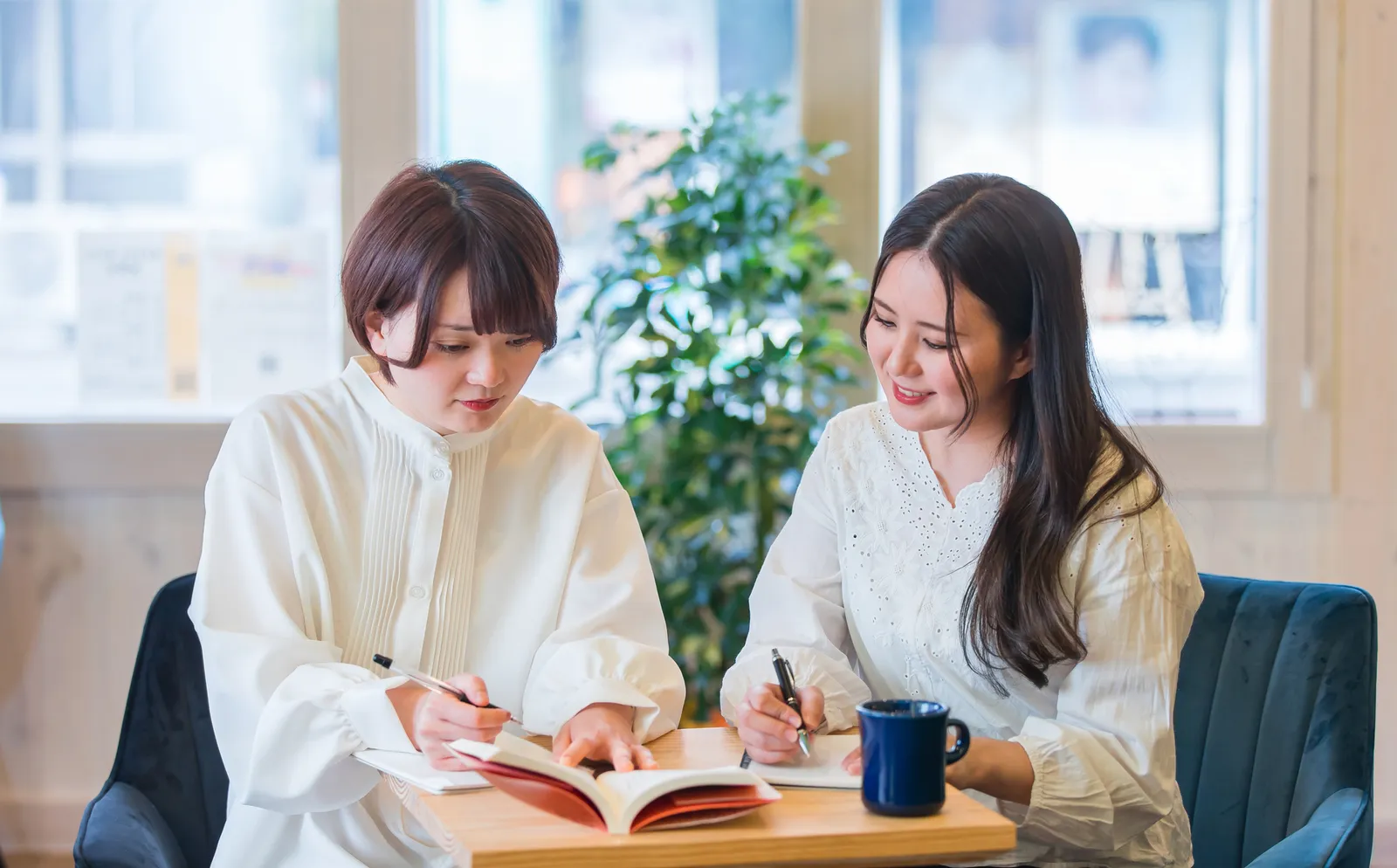 ノートを開いて研修に取り組む二人の社員