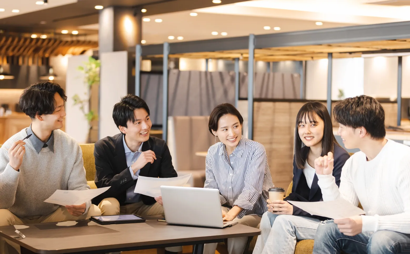 ショールームのラウンジで打ち合わせをする五人の社員